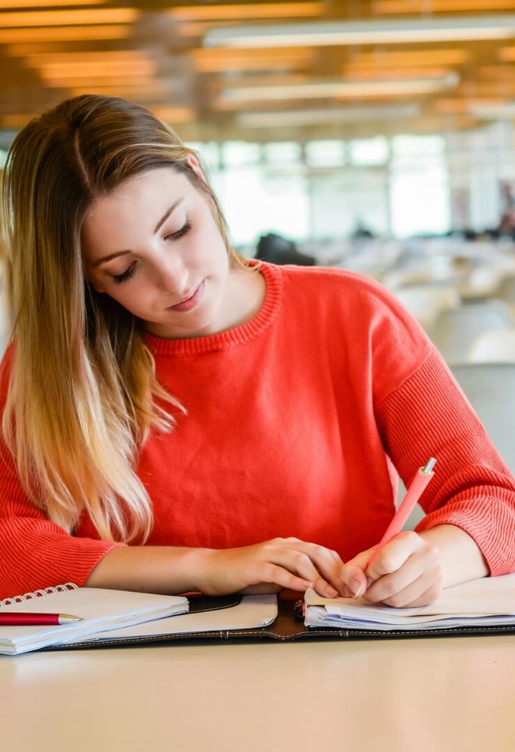 A woman writing on a notebook